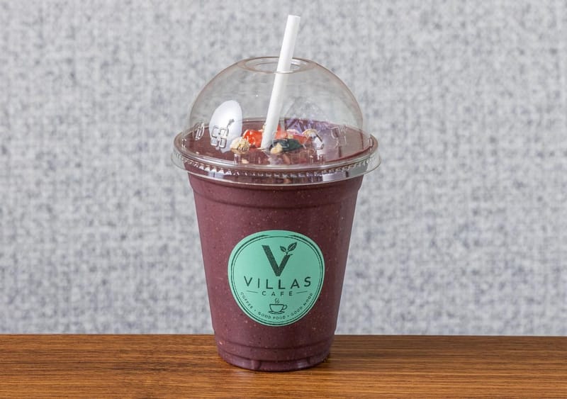 Açaí Power smoothie, deep purple and topped with granola, in a Villas Cafe takeaway cup